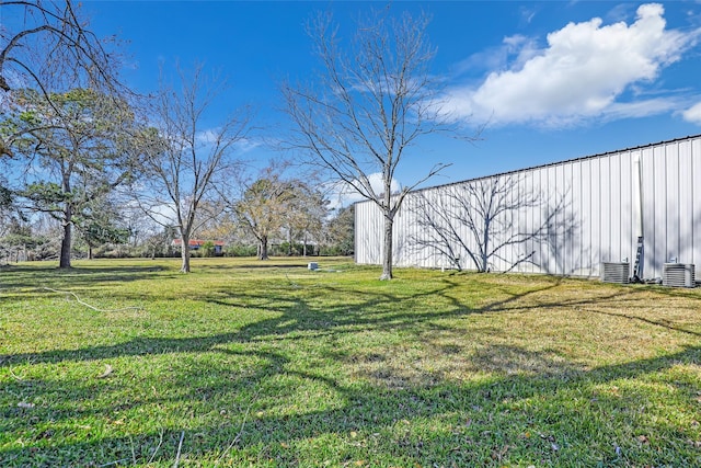 view of yard featuring central AC unit and an outdoor structure