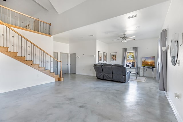 unfurnished living room with ceiling fan, concrete flooring, and a towering ceiling