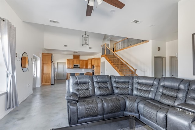 living room featuring ceiling fan and a high ceiling