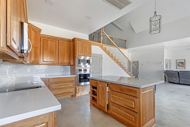 kitchen with appliances with stainless steel finishes, decorative light fixtures, a center island, and backsplash