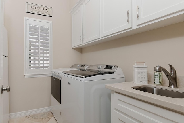 washroom featuring cabinets, sink, and washer and dryer