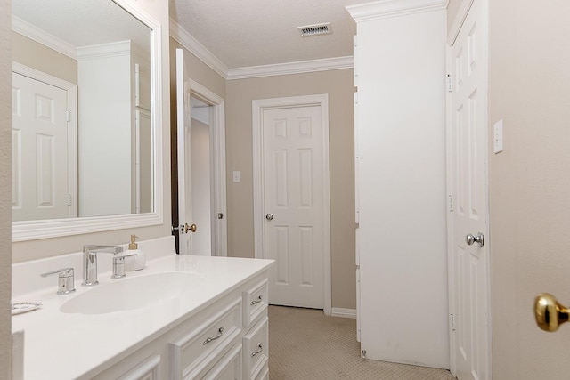 bathroom featuring ornamental molding, vanity, and a textured ceiling