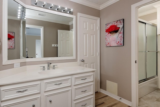 bathroom featuring vanity, hardwood / wood-style floors, ornamental molding, and shower / bath combination with glass door