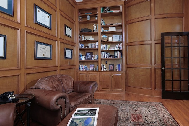 living area with hardwood / wood-style floors and built in shelves