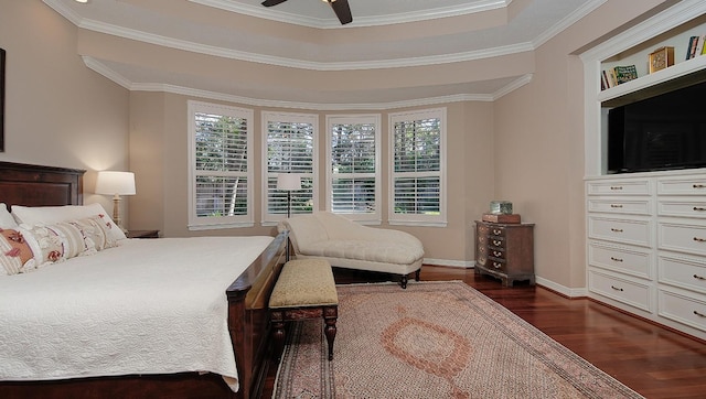 bedroom with crown molding, dark hardwood / wood-style floors, a raised ceiling, and multiple windows