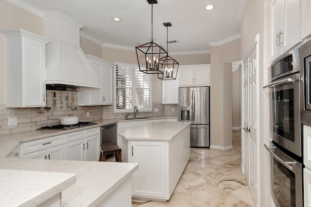 kitchen featuring sink, hanging light fixtures, appliances with stainless steel finishes, a kitchen island, and white cabinets