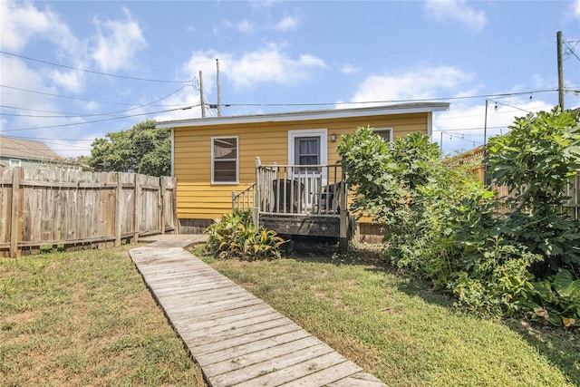 back of house with a yard and a deck