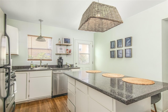 kitchen with dark hardwood / wood-style floors, sink, white cabinets, a center island, and stainless steel appliances