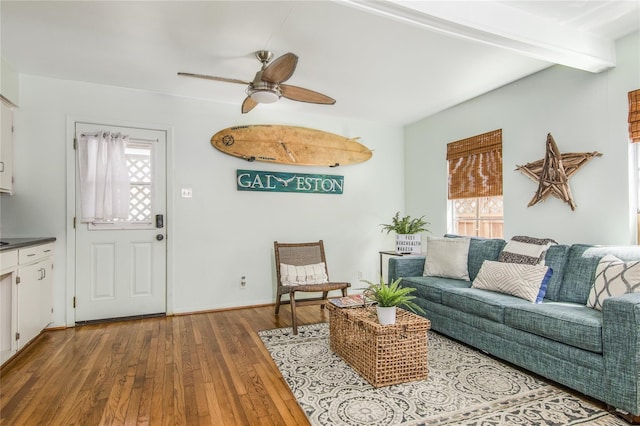 living room with beam ceiling, wood-type flooring, plenty of natural light, and ceiling fan