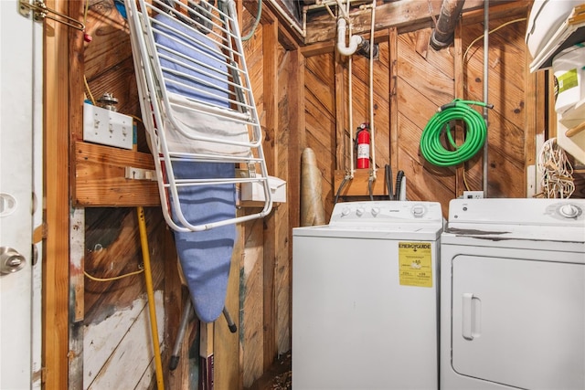 laundry room with separate washer and dryer and wooden walls