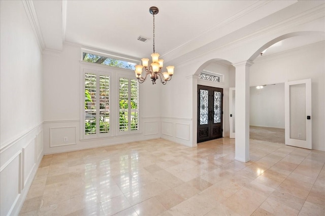 tiled empty room featuring french doors, a healthy amount of sunlight, crown molding, and a notable chandelier