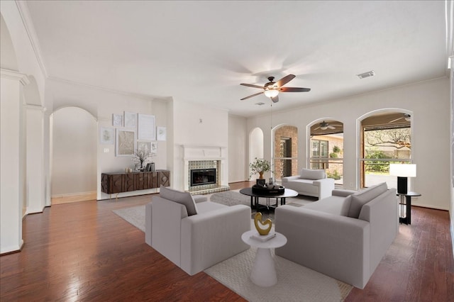 living room with crown molding, dark hardwood / wood-style floors, and ceiling fan