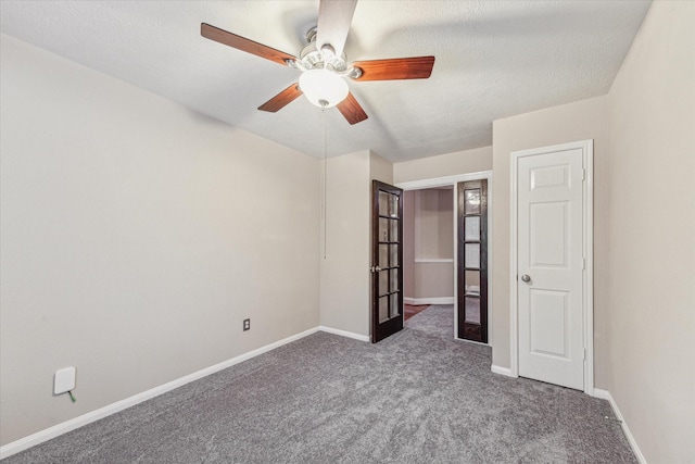 unfurnished bedroom with a textured ceiling, ceiling fan, and carpet