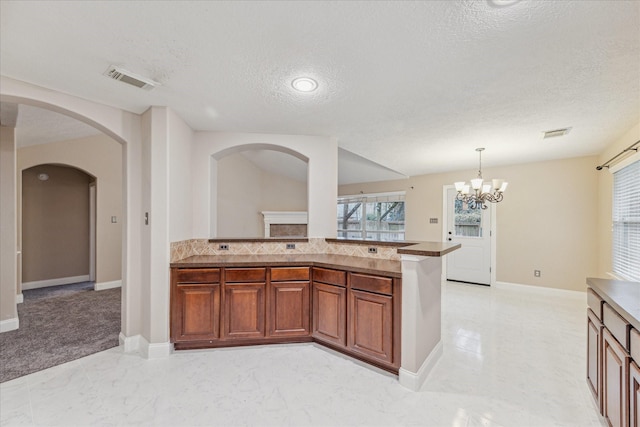 kitchen with an inviting chandelier, hanging light fixtures, and a textured ceiling