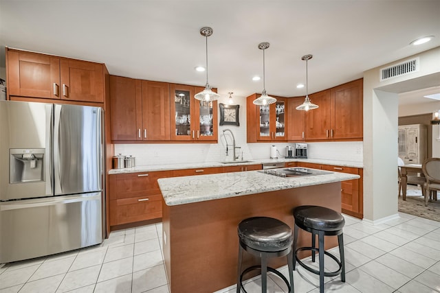 kitchen with stainless steel refrigerator with ice dispenser, a center island, sink, and light tile patterned flooring