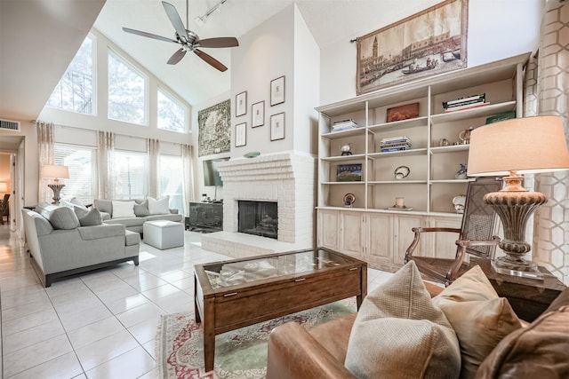 living room with a fireplace, high vaulted ceiling, ceiling fan, and light tile patterned flooring