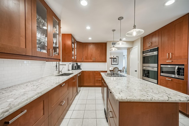 kitchen featuring tasteful backsplash, sink, stainless steel appliances, and a kitchen island