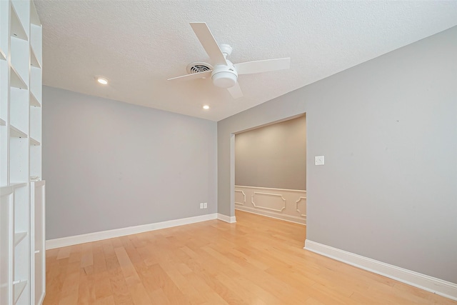 unfurnished room featuring a textured ceiling, ceiling fan, and light wood-type flooring