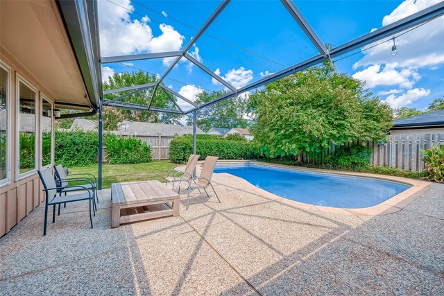 view of swimming pool with a patio and a lanai