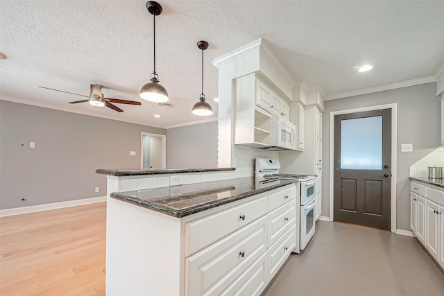 kitchen featuring double oven range, decorative light fixtures, white cabinets, and backsplash