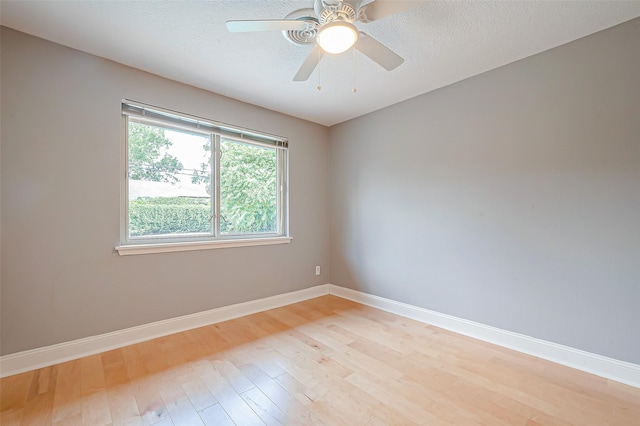 spare room featuring ceiling fan, light hardwood / wood-style floors, and a textured ceiling