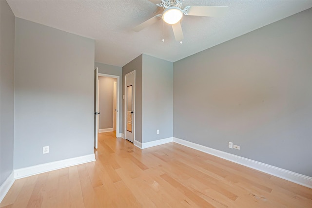 unfurnished room with a textured ceiling, ceiling fan, and light hardwood / wood-style flooring