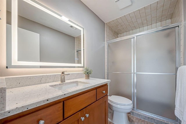 bathroom with a shower with door, vanity, and toilet