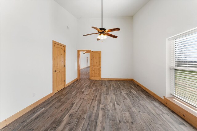 interior space featuring hardwood / wood-style flooring, a high ceiling, and ceiling fan