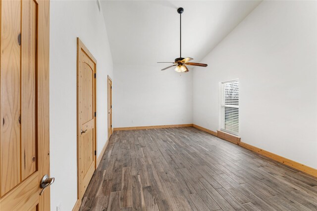 unfurnished room with dark wood-type flooring, high vaulted ceiling, and ceiling fan