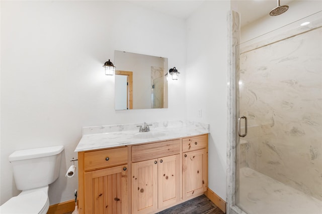 bathroom with vanity, toilet, a shower with door, and hardwood / wood-style floors