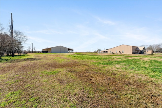 view of yard featuring a rural view and an outbuilding