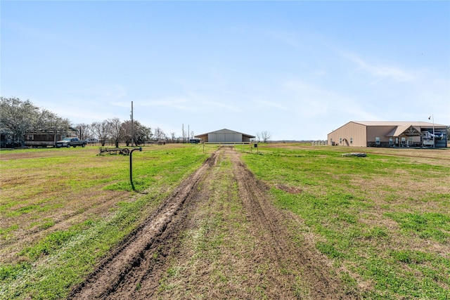 view of yard featuring a rural view and an outbuilding