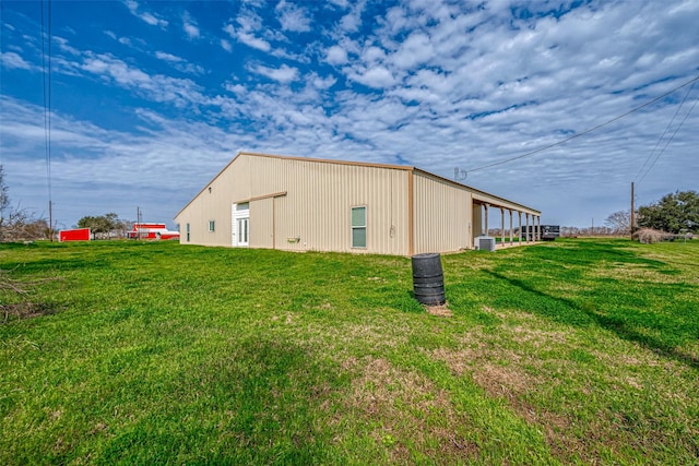 view of outbuilding with central AC and a lawn