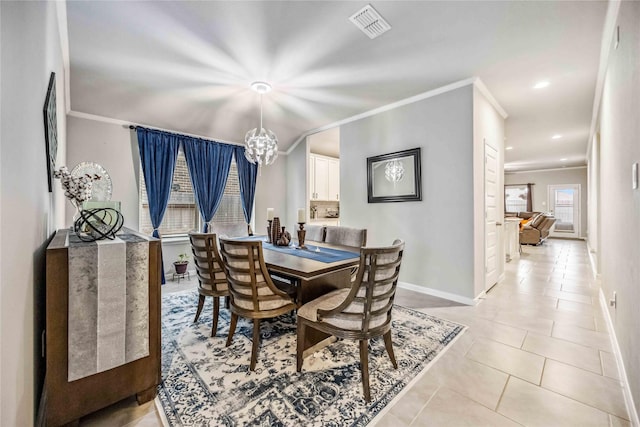 tiled dining space with an inviting chandelier and ornamental molding