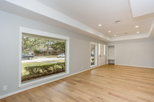 empty room featuring light hardwood / wood-style flooring and a raised ceiling