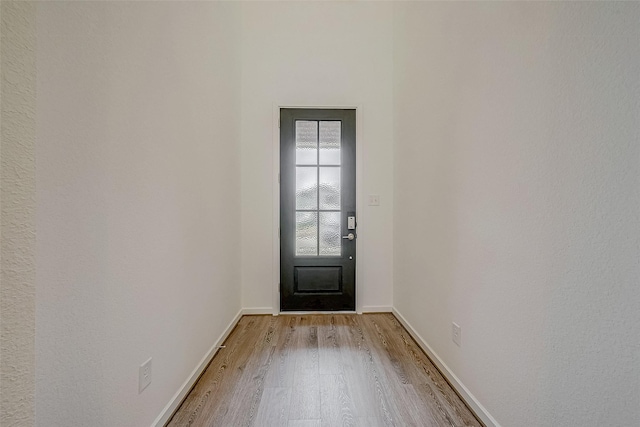 doorway featuring light wood-type flooring and baseboards