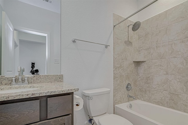 full bathroom featuring a textured wall, shower / bath combination, vanity, and toilet