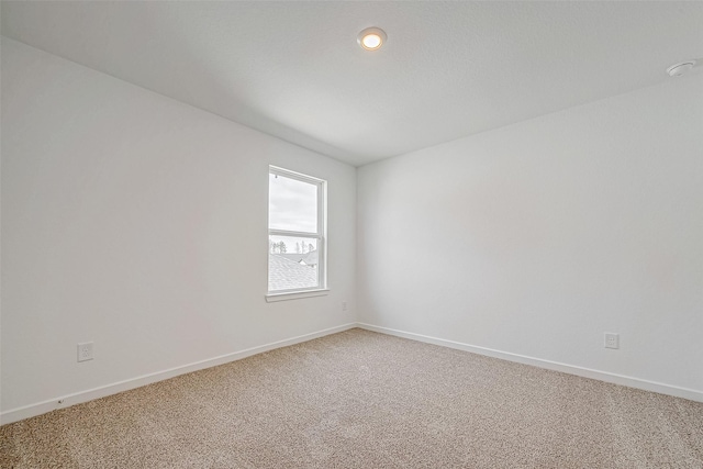 carpeted empty room with baseboards