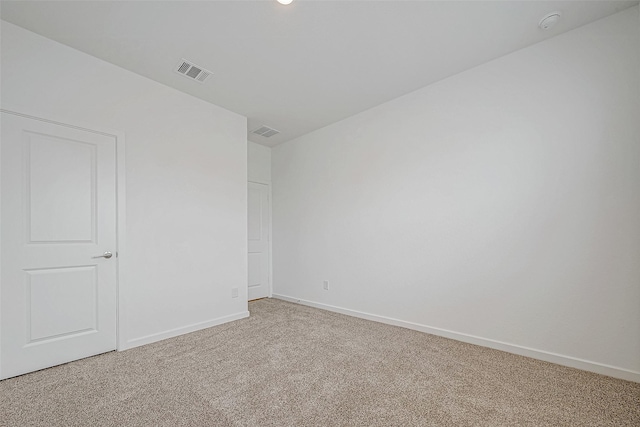 carpeted empty room featuring baseboards and visible vents