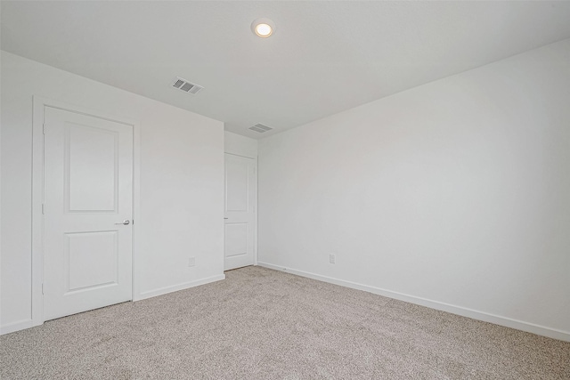 empty room featuring carpet floors, recessed lighting, visible vents, and baseboards