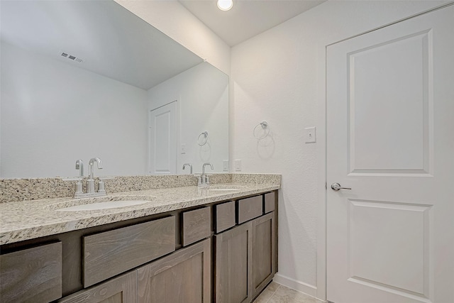 bathroom featuring visible vents, a sink, baseboards, and double vanity