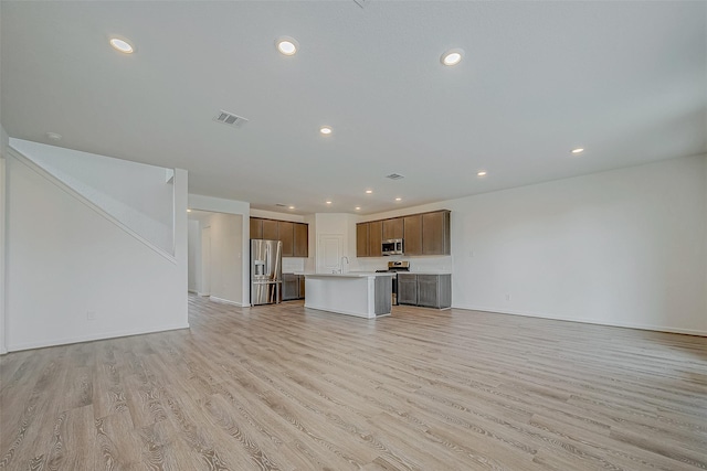 unfurnished living room featuring light wood-style floors, recessed lighting, visible vents, and a sink