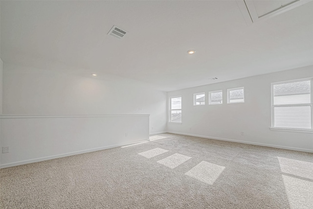 unfurnished room with light carpet, recessed lighting, visible vents, and baseboards