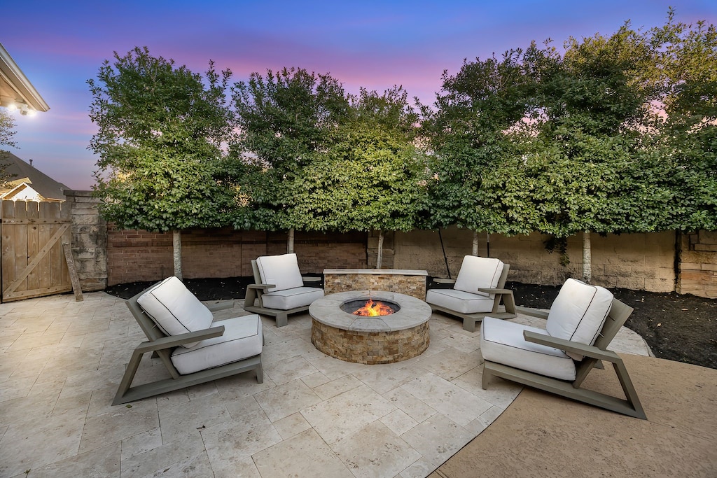 view of patio with an outdoor fire pit and fence