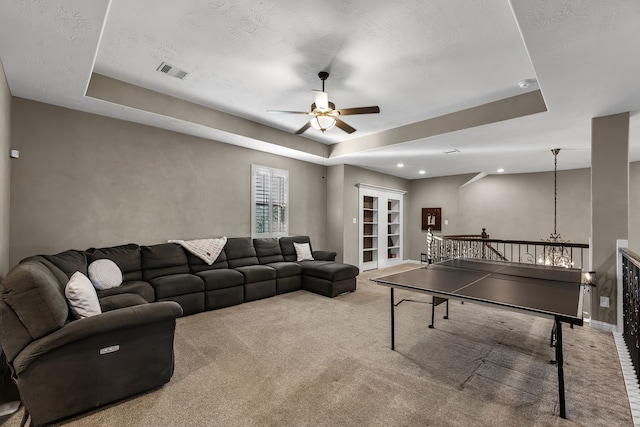 game room with a tray ceiling, visible vents, ceiling fan, and carpet flooring