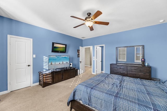 bedroom featuring light carpet, ceiling fan, and baseboards