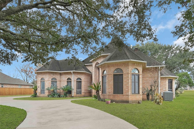 view of front facade with a front lawn and central air condition unit