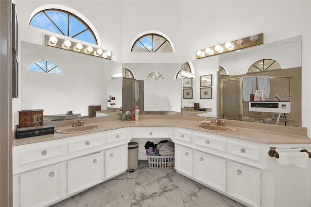 bathroom with vanity, a towering ceiling, and walk in shower