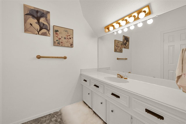 bathroom with lofted ceiling, vanity, and a textured ceiling