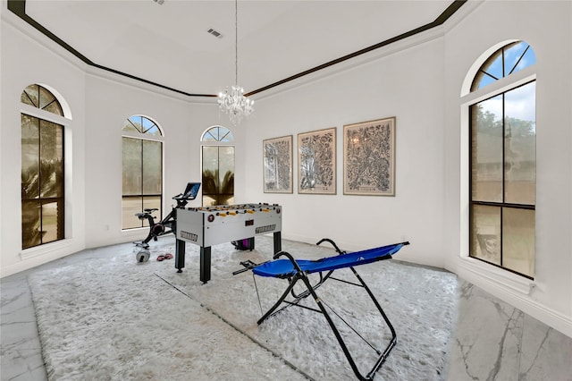 game room with crown molding and an inviting chandelier